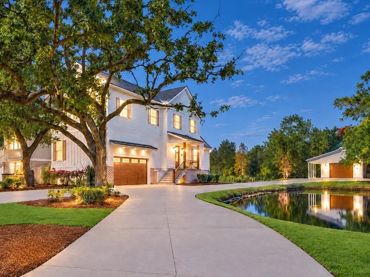 White two-story home with a long driveway and pond at 5068 South First St, Murrells Inlet, SC.